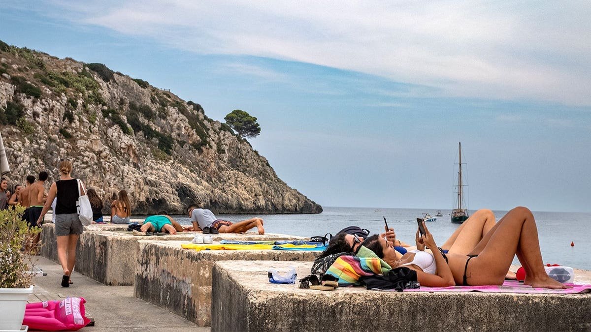 People in Italy sunbathing on beach