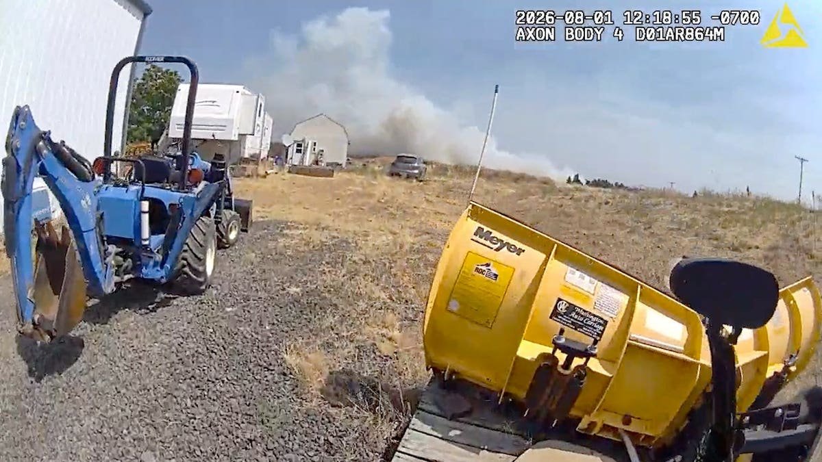 Paul Child stands beside a white pickup truck on a rural road in Airway Heights, Washington, in police body-camera footage.