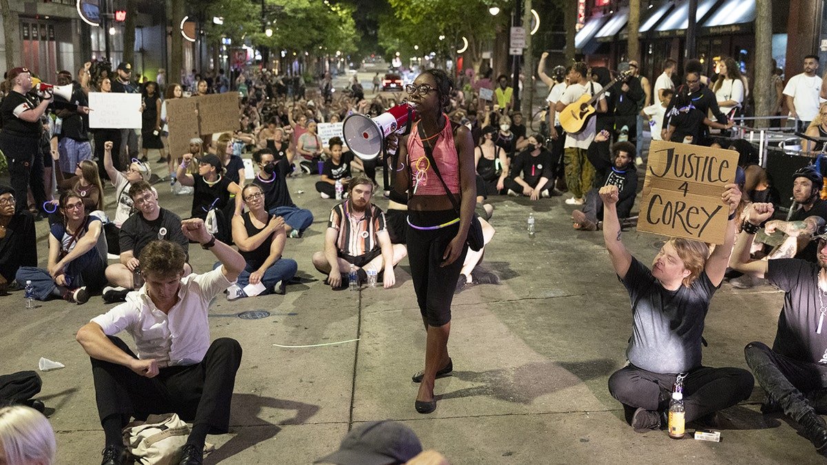 Protesters sit in a downtown Madison street during demonstrations following the fatal police shooting of Corey Ruiz.