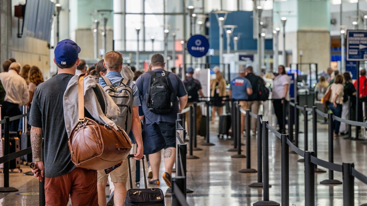 Passengers line up at airport security