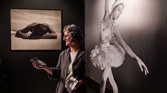 State Library of NSW curator Avryl Whitnall poses for a photograph alongside Max Dupain’s work.