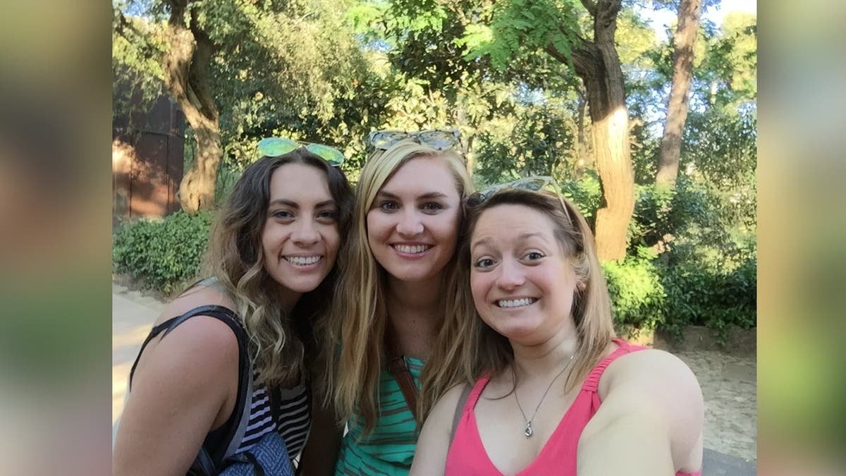Victoria, Brooke and Jennifer smile for a selfie in front of a tree.