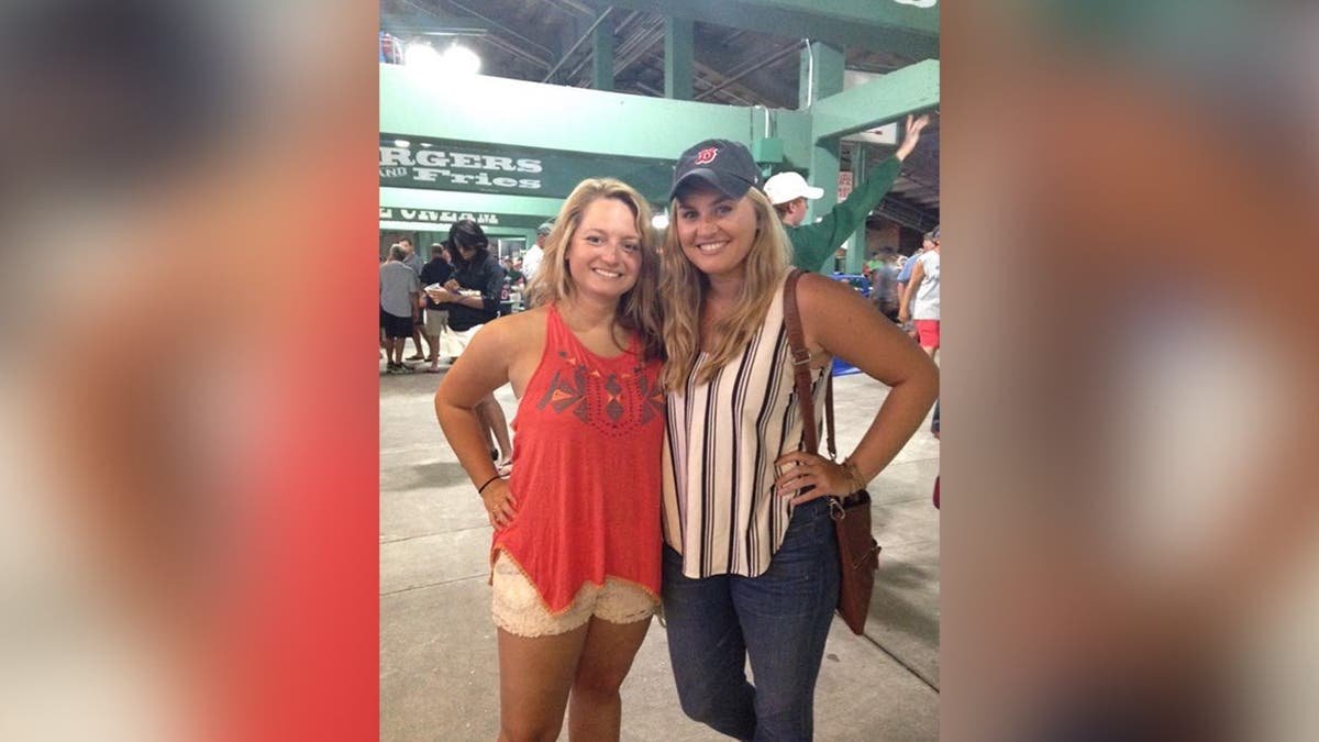 Brooke Hanlon and Jennifer Payne pose together at a Red Sox baseball game in Boston.