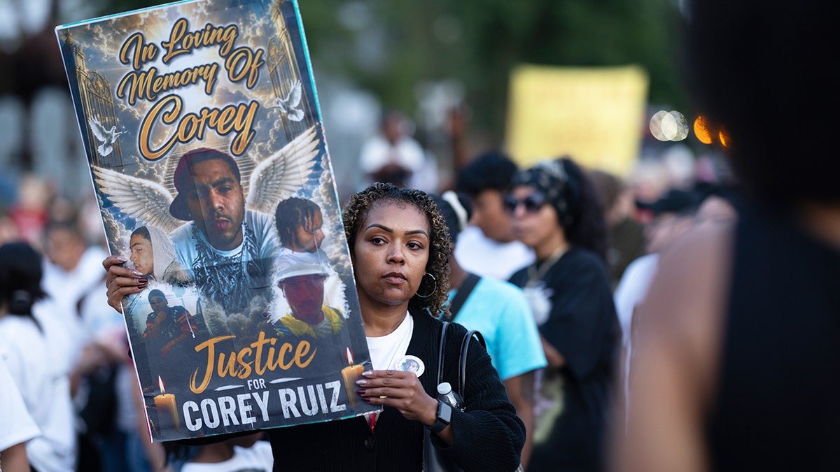 A protester holds a memorial poster for Corey Ruiz during a demonstration in Madison, Wisconsin.