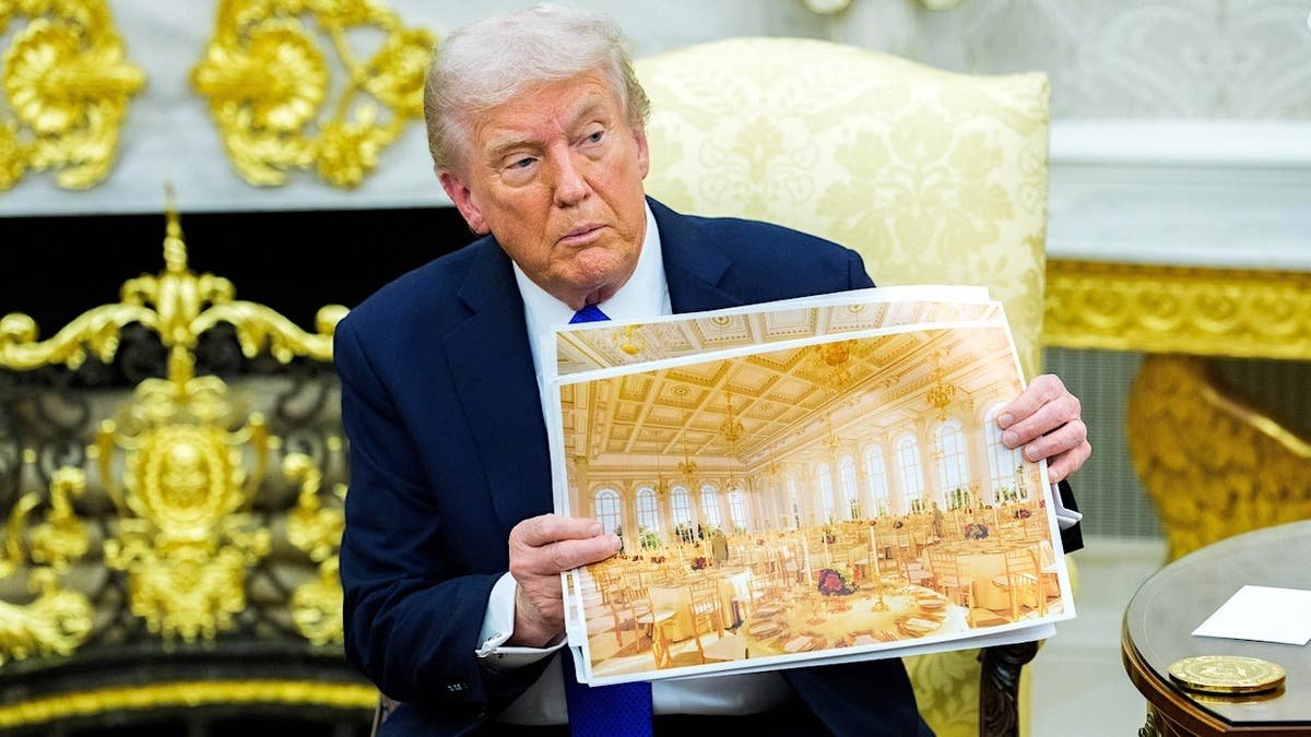 President Donald Trump holds a design rendering of a proposed $400 million presidential ballroom at the White House.
