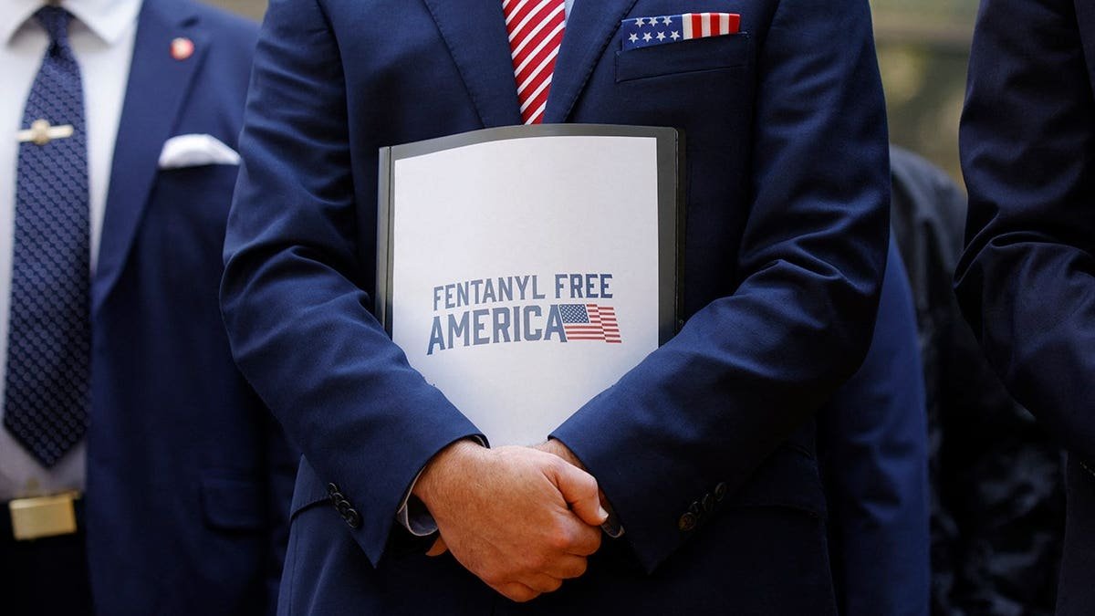 Terrance Cole holds a folder reading 
