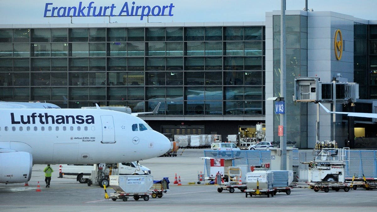 Lufthansa Airbus A320 aircraft parked at Remote Stand V143 beside the Frankfurt Airport terminal.
