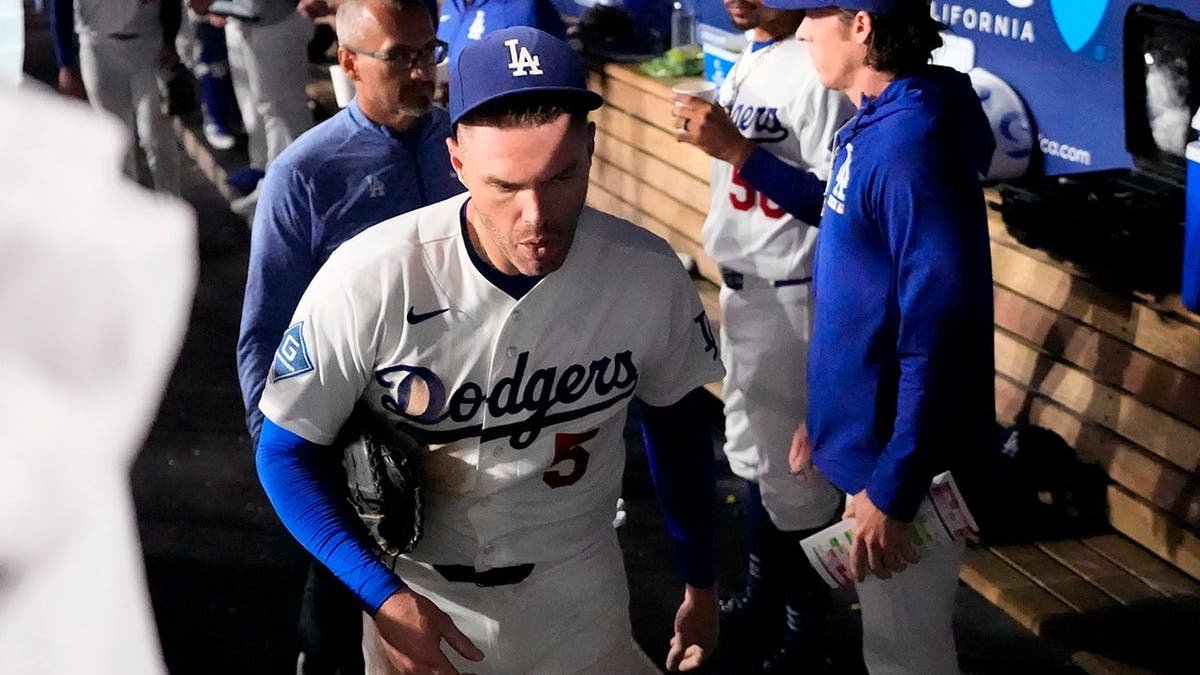 Freddie Freeman leaves the field after falling into the visitors dugout while attempting to catch a foul ball.