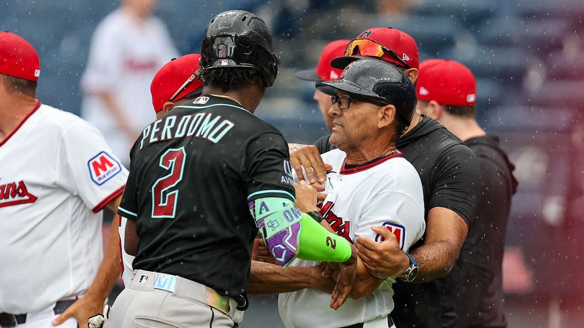 Geraldo Perdomo separates Rouglas Odor during a bench-clearing scene at Progressive Field.