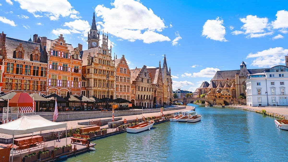 Graslei quay and River Lys waterfront in Ghent, Belgium, under sunny skies.