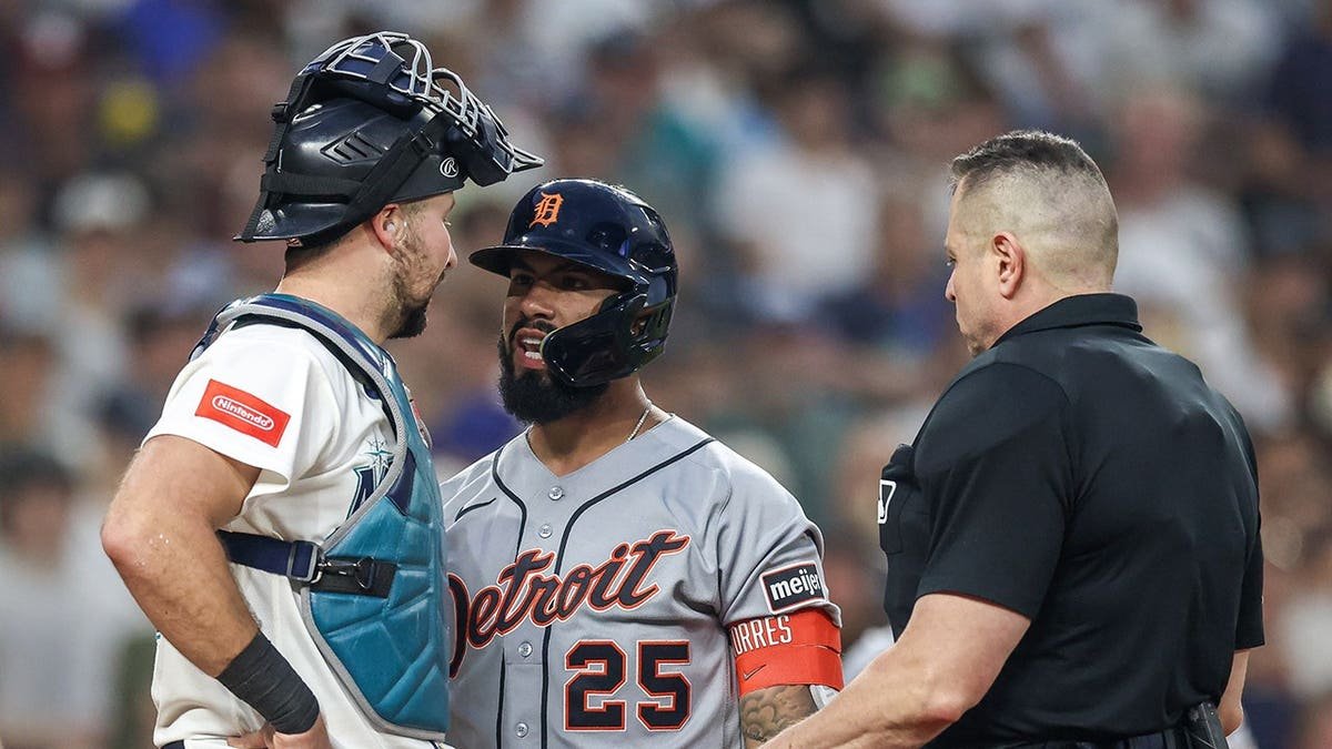 Gleyber Torres of the Detroit Tigers confronts Cal Raleigh of the Seattle Mariners during a baseball game.