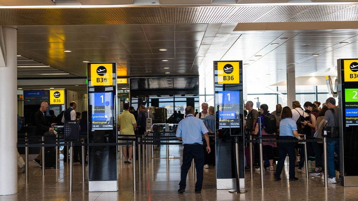 Travelers wait to board an aircraft at London Heathrow Airport in London