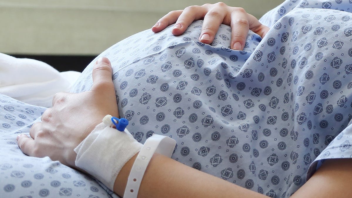 Pregnant woman places hand on belly