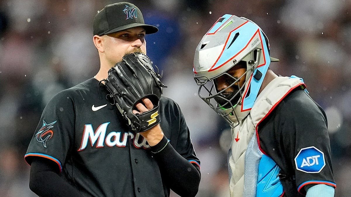 Janson Junk speaks with catcher Brian Navarreto during a baseball game.
