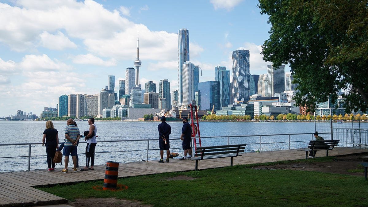 People look out across Lake Ontario and the Toronto Skyline from the Toronto Harbour in Toronto on Tuesday, Aug. 25, 2026. (Keito Newman/The Canadian Press via AP)