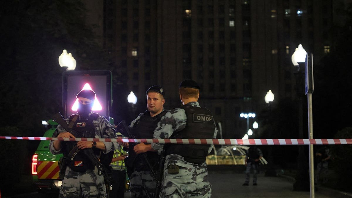 Law enforcement officers stand guard at the site of an explosion in central Moscow.