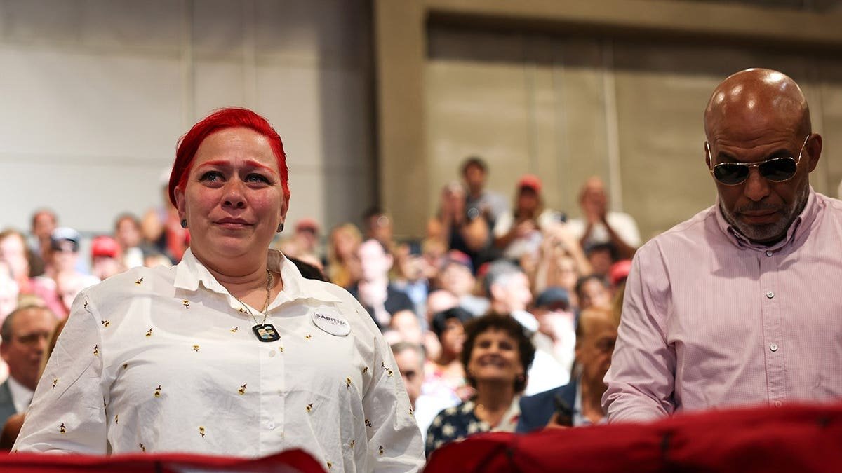 Migdalia Martinez reacts as President Trump recognizes her at an event in Garden City, New York.