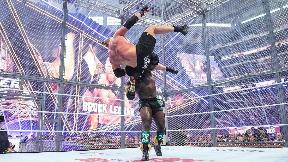 Oba Femi grapples with Brock Lesnar during a wrestling match at U.S. Bank Stadium.