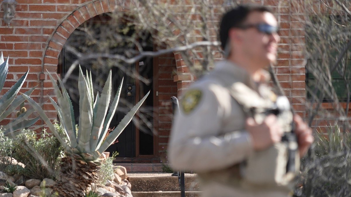 A member of the Pima County Sheriff's Department standing by a truck outside Nancy Guthrie‘s house.