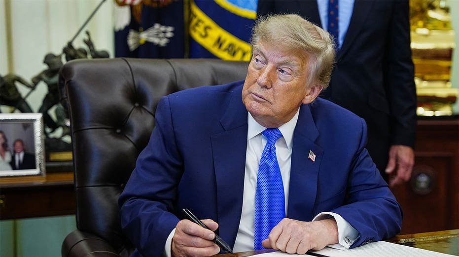 President Donald Trump signs an executive order in the Oval Office at the White House