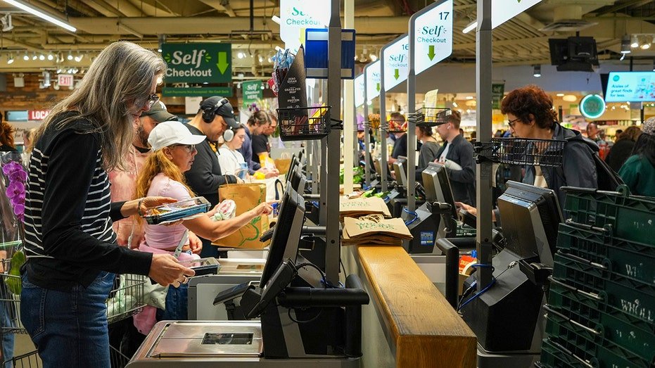 Customers use self checkout at Whole Foods