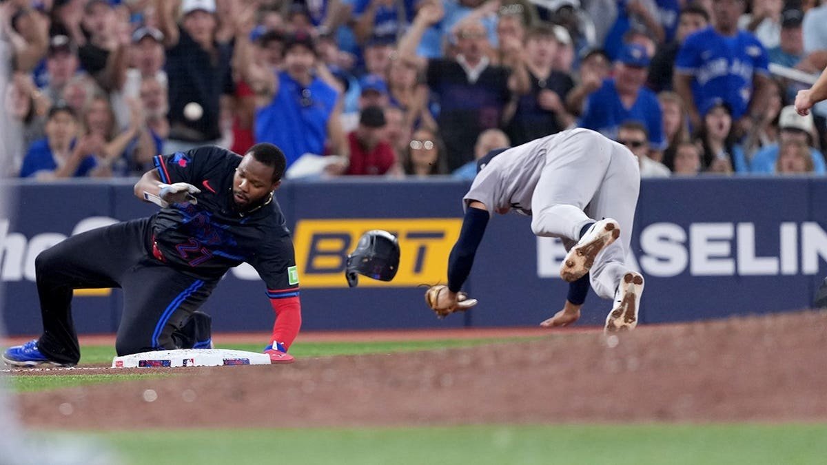 Vladimir Guerrero Jr. runs into George Lombard Jr. during a baseball game at Rogers Centre.