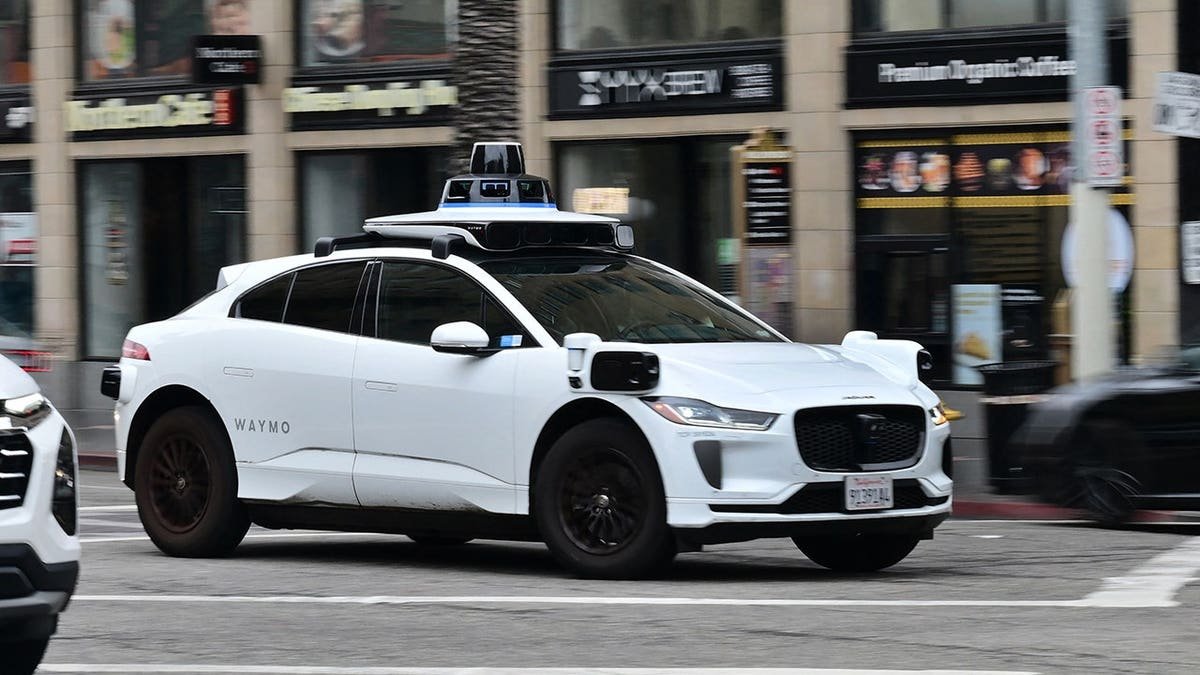 A Waymo driverless vehicle driving on Hollywood Boulevard in Los Angeles