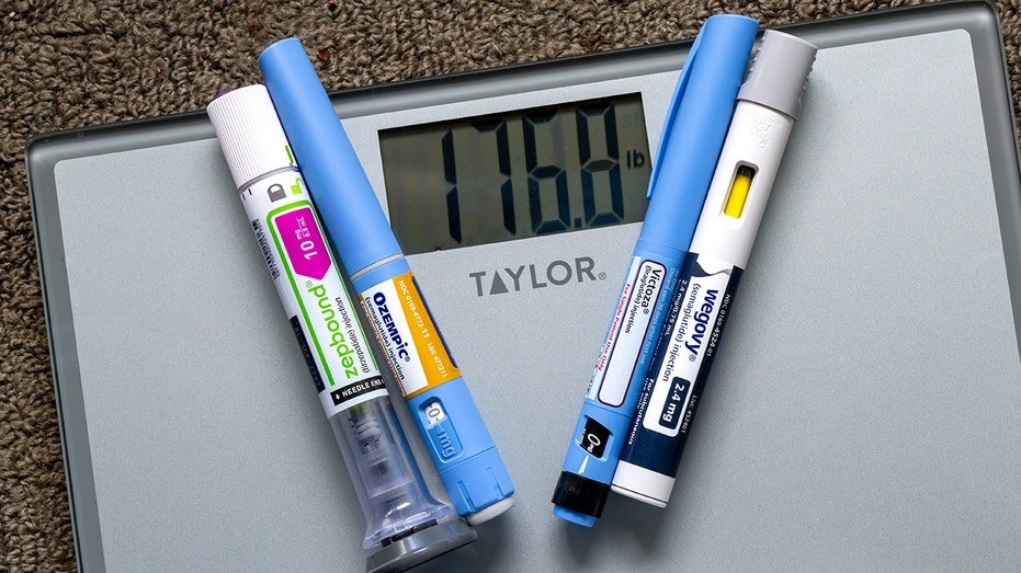 photo illustration of weight loss injection pens on a weight scale showing 176 pounds