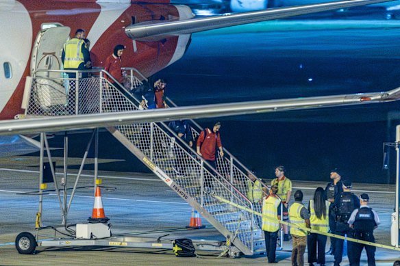 Members of the Iranian women’s soccer team disembark in Sydney on their way back to Iran.