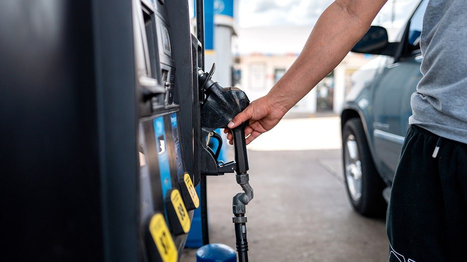 Person's hand pulls for gas station pump