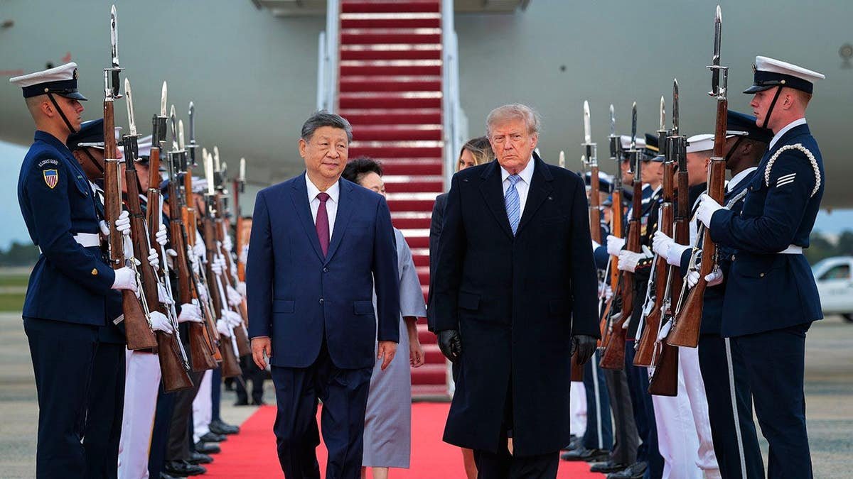 President Donald Trump walks on a red carpet after greeting Chinese President Xi Jinping at Joint Base Andrews.