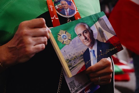 An attendee holds a photo of Reza Pahlavi, son of Iran’s last Shah, as he speaks in Texas earlier this year. 