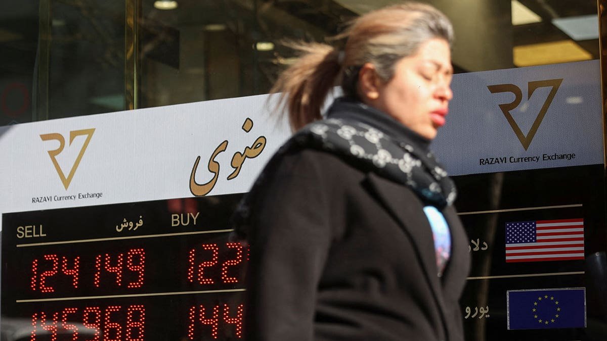 A person walks past a sign at a currency exchange, as the value of the Iranian Rial drops, in Tehran, Iran, December 30, 2025.