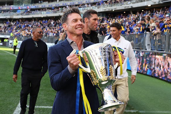 Ben Cousins carries the 2006 Premiership Cup around the field with former teammates in 2026.