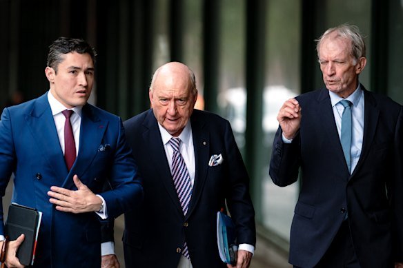 Alan Jones (centre) arrives at Downing Centre Local Court with his lawyers on Wednesday.