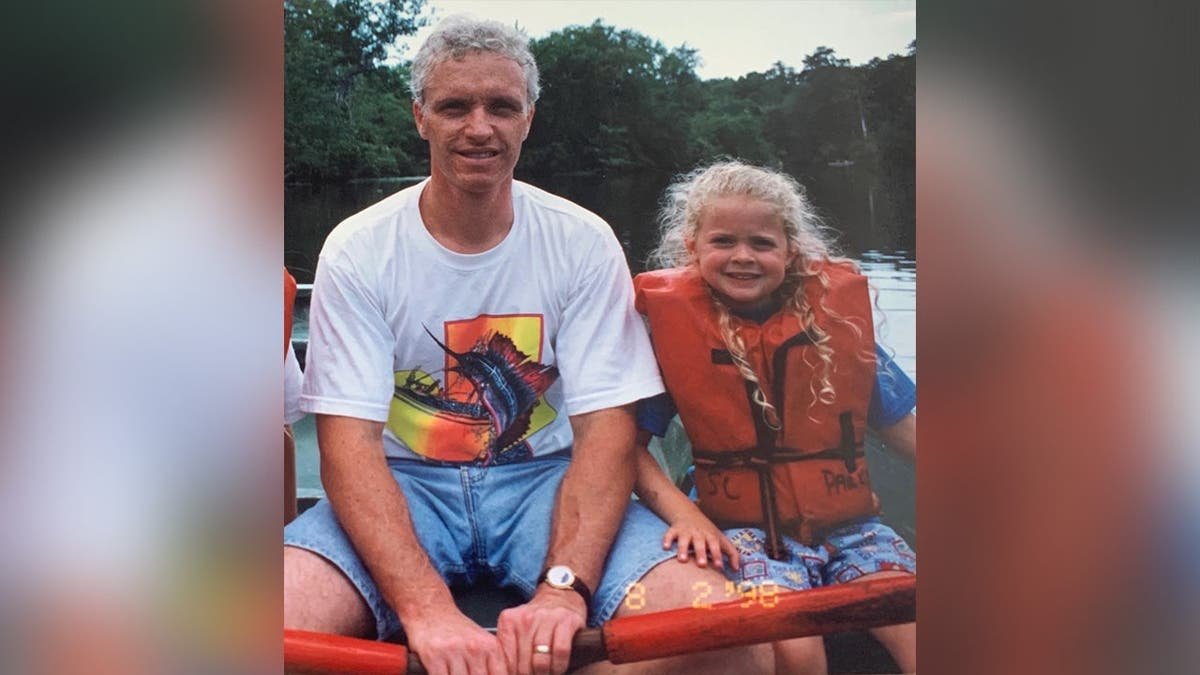 image shows father posing with daughter wearing a life vest