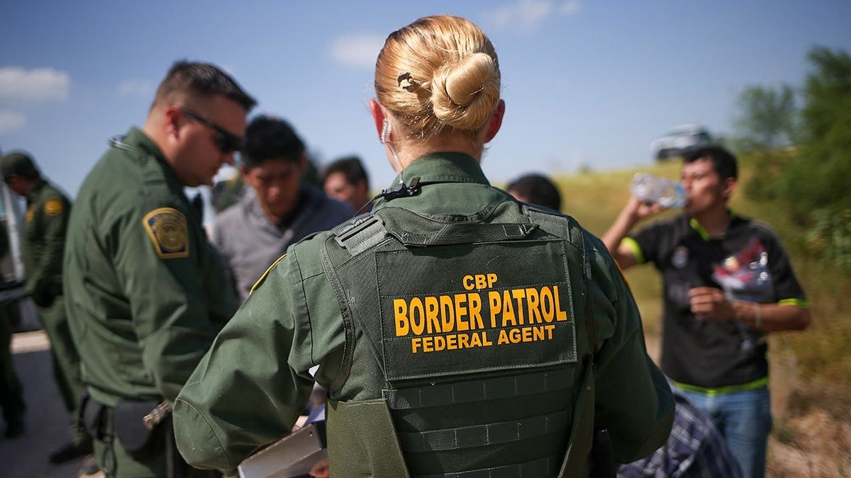 Border Patrol agents processing illegal immigrants.