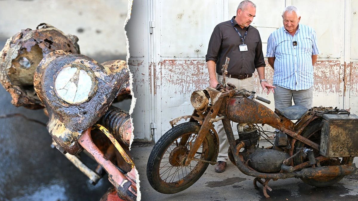 View of motorcycle next to two men inspecting it