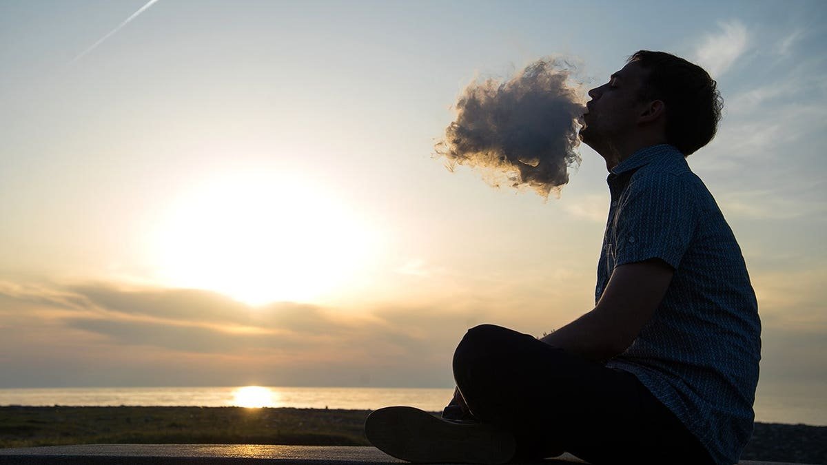 Stock imaging of man smoking on beach