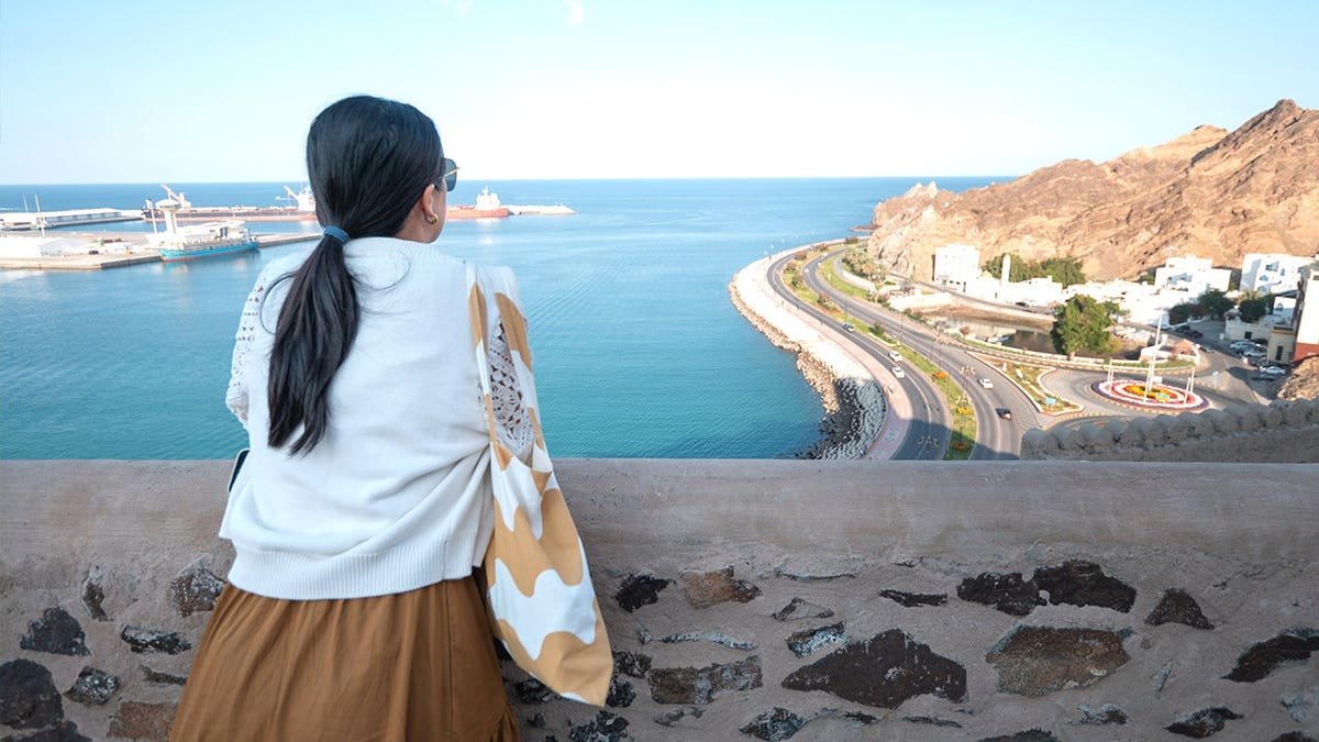 Woman standing looking at skyline in Oman