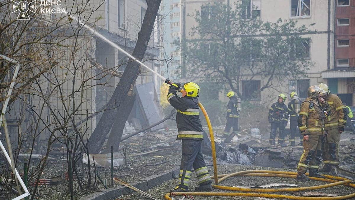 Firefighters work at a site of an apartment building hit by a Russian drone strike, amid Russia's attack on Ukraine, in Kyiv