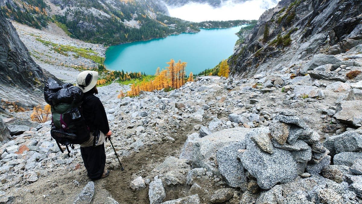 Backpacker viewing Colchuck Lake from Aasgard Pass, The Enchantments