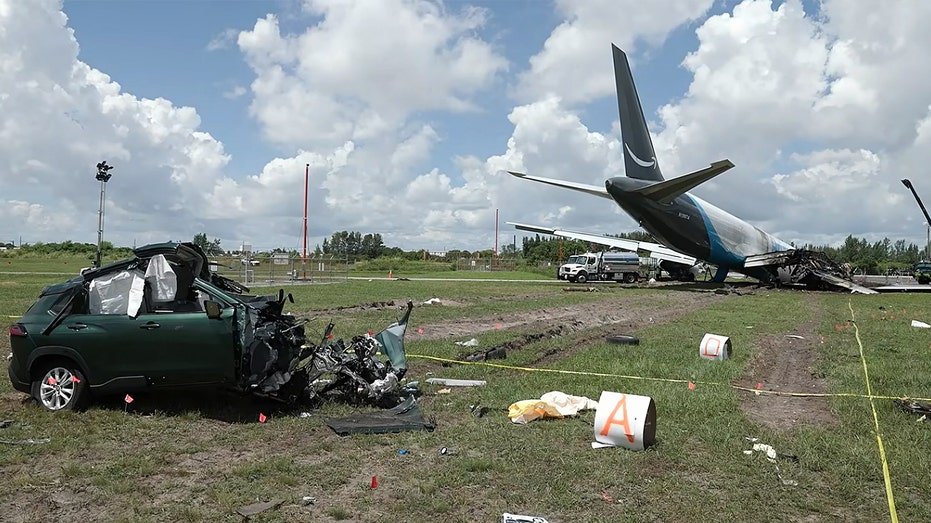 Damaged car near plane crash.
