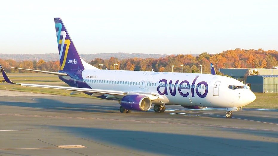 An Avelo Airlines aircraft parked on an airport tarmac.
