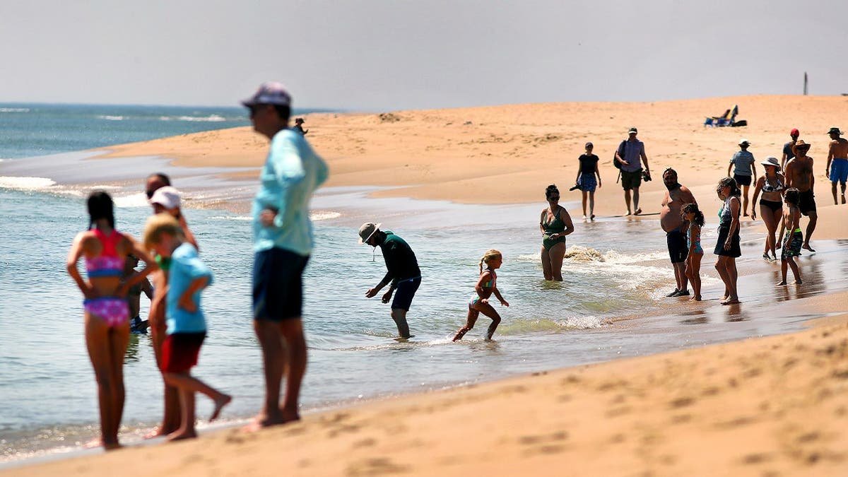 People stand along the shoreline of Coast Guard Beach.