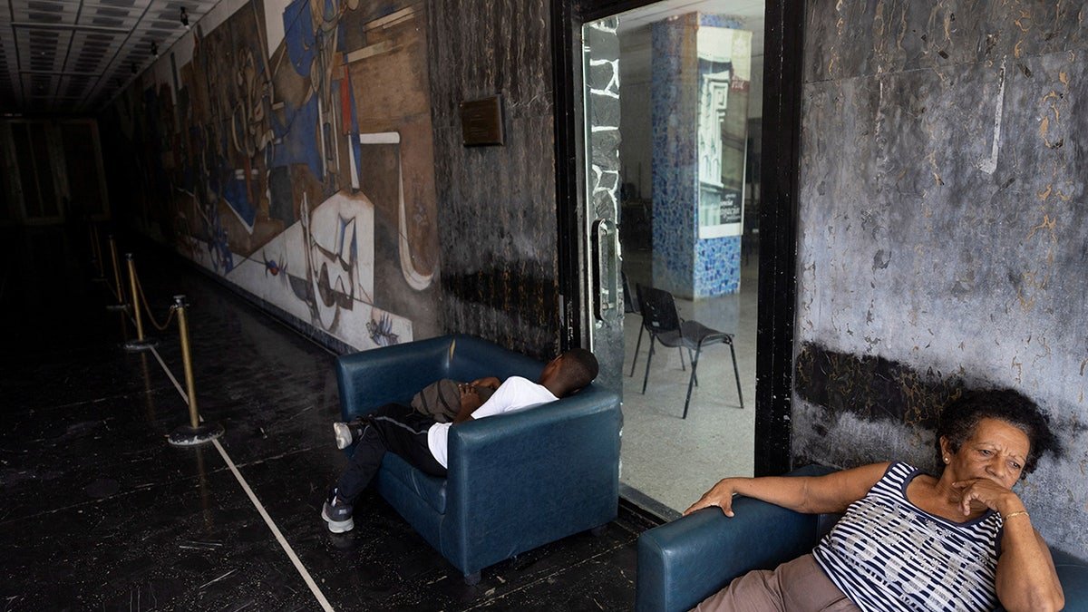 People sit in a darkened building lobby during a power outage in Havana, Cuba, September 18, 2026. REUTERS/Ricardo Arduengo