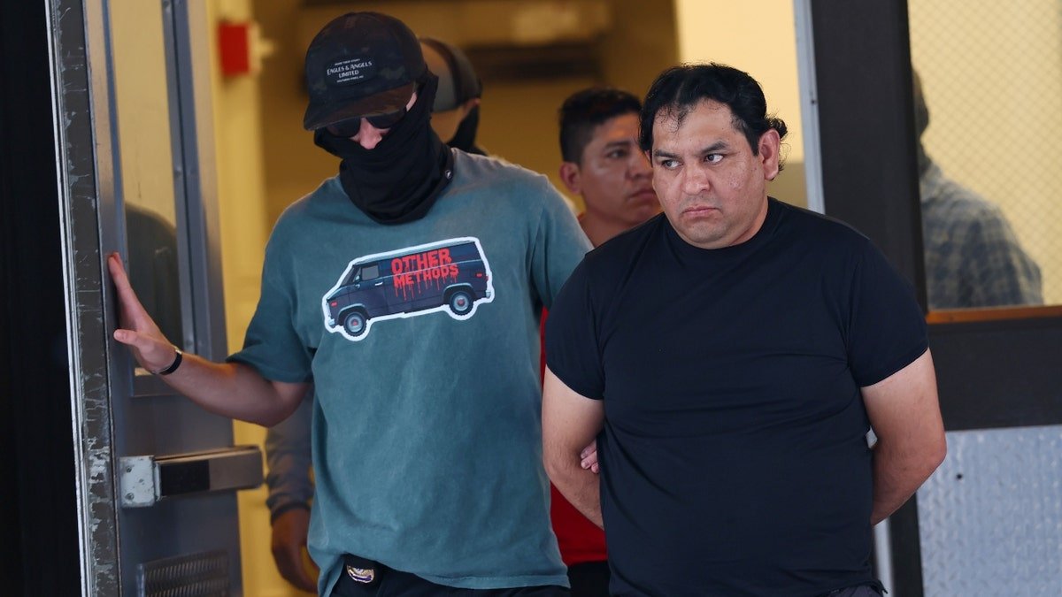 Federal agents escort detainees to vehicles after exiting an Intensive Supervision Appearance Program office on June 04, 2025 in New York City.