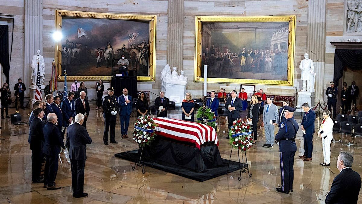 Members of Congress stand near Chief Warrant Officer Hershel Woodrow Williams as his remains lie in honor in the Capitol Rotunda.