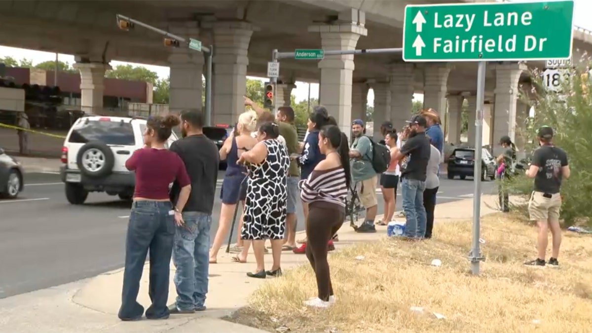A crowd gathers near the scene of the shooting.