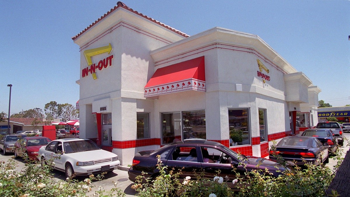 A line of vehicles is wrapped around an In-N-Out building.